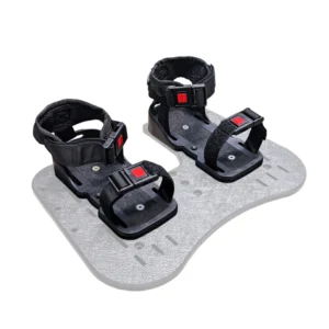 Close-up of black snowboard bindings with red buckles mounted on a textured gray board