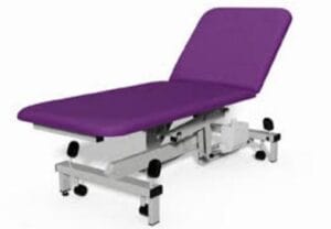 Purple cushioned medical examination/therapy table with adjustable sections and metal base.