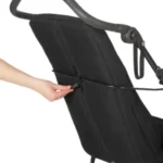 Close-up of a hand tightening a strap on a black reclining chair's backrest for support