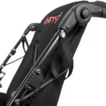Close-up of a black folding chair/seat mechanism showing a metal hinge, bolts, and a fabric strap.