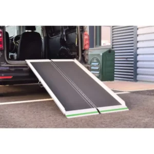 Wheelchair ramp extended from a van, ready for boarding on a paved surface.