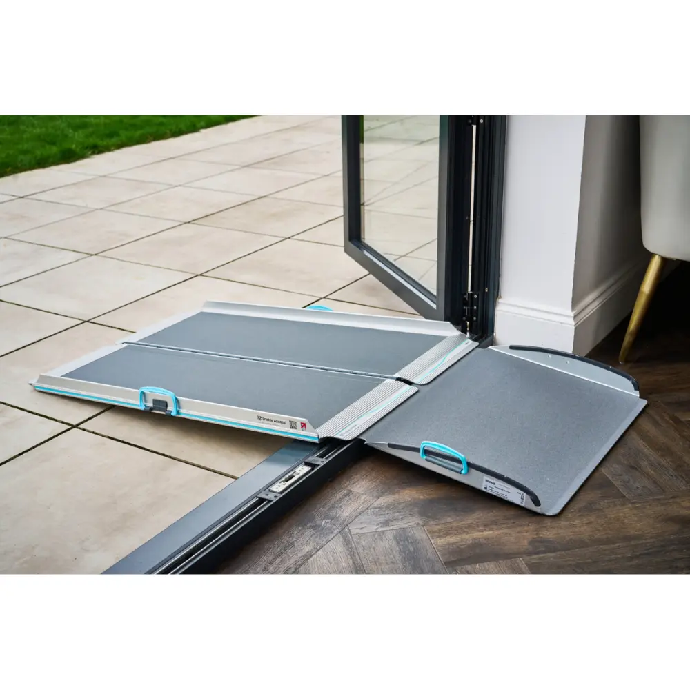 Aerolight Up Over 3 - O Neill Healthcare Foldable doorway ramp extending from an open glass door onto a tiled patio, with blue-handled panels ready to use