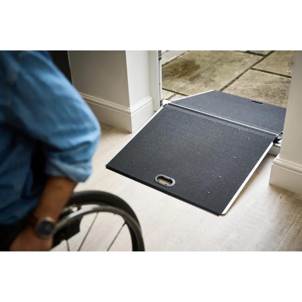 Doorline Butterfly Ramp 3 - O Neill Healthcare Wheelchair user approaching a portable ramp extending over a doorway threshold to enter a house picnically.